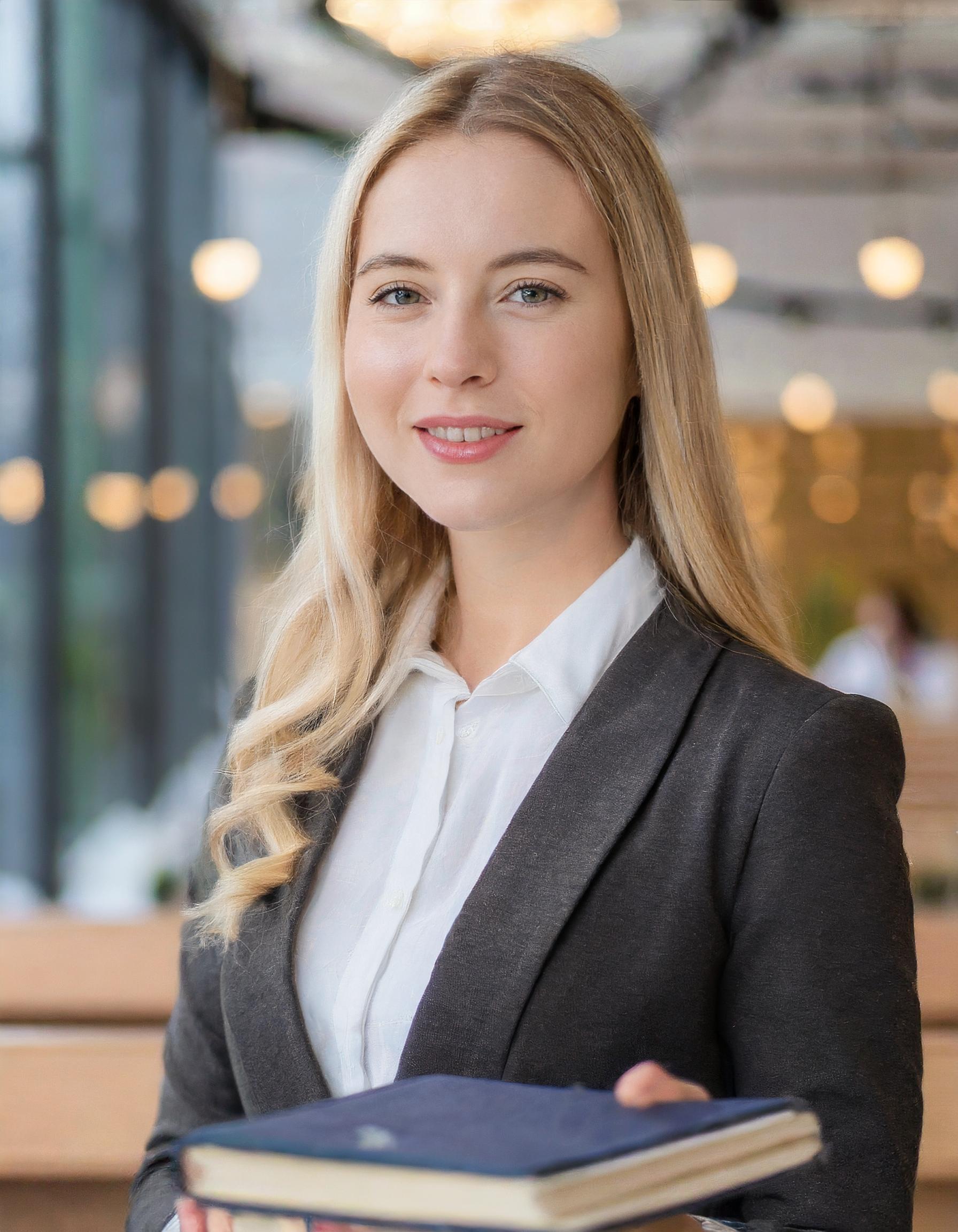 Porträt einer Frau, freundlich lächelnd, in einem klassischen Büroambiente
